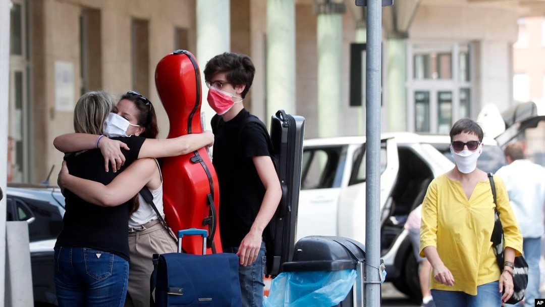 As Italy opened its border, Giuseppina Niglio, from Salerno, southern Italy, hugs her children Roberta and Alessandro, students at the Lugano School of music Conservatory in Switzerland, at the Italian-Swiss border, June 3, 2020. 