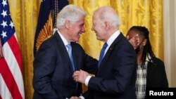 Presiden AS Joe Biden menyapa mantan Presiden Bill Clinton dalam acara peringatan 30 tahun dibentuknya Undang-undang Cuti Keluarga di Gedung Putih, Washington, pada 2 Februari 2023. (Foto: Reuters/Kevin Lamarque)