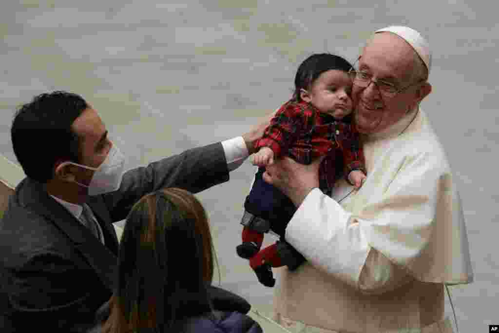 پاپ فرانسیس در مراسمی در واتیکان، یک نوزاد را به آغوش گرفته است. این بخشی از دیدارهای عمومی پاپ در آستانه کریسمس است. 