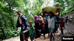 Sekelompok orang Rohingya berjalan menuju tempat penampungan sementara di dekat perbatasan Bangladesh-Myanmar di Cox's Bazar, Bangladesh, 28 Agustus 2017.