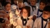 Choristers light candles during a rehearsal for Christmas services at St. Paul's Cathedral in London, Britain, Dec. 23, 2024. St. Paul's choir includes girls for the first time in its 900-year history. 