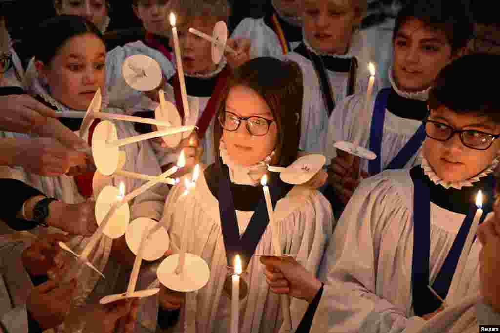 Choristers light candles during a rehearsal for Christmas services at St. Paul&#39;s Cathedral in London, Britain. St. Paul&#39;s choir includes girls for the first time in its 900-year history. REUTERS/Jaimi Jo