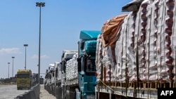 Camiones que transportan ayuda humanitaria con destino a la Franja de Gaza hacen fila frente al cruce fronterizo de Rafah, el 23 de marzo de 2024. 