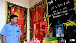 FILE - Le Minh Tuan, father of the late 30-year-old Le Van Ha who was among 39 people found dead in a truck in Britain last year, cries in front of his son's prayer altar in their house in Vietnam's Nghe An province, Oct. 10, 2020..