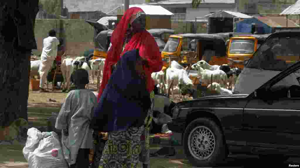 A woman and two children stand along the Jos-Maiduguri road as they wait to board a vehicle, after the military declared a 24-hour curfew over large parts of Maiduguri in Borno State May 19, 2013.