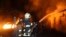 Украинские пожарные борятся с огнем после российского обстрела жилых кварталов Харькова. Февраль 2024 г. 
