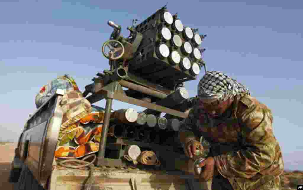 A rebel fighter scrubs his missiles at a front line checkpoint on the road between Bin Jawad and Nawfiliyah, Libya, March 29, 2011