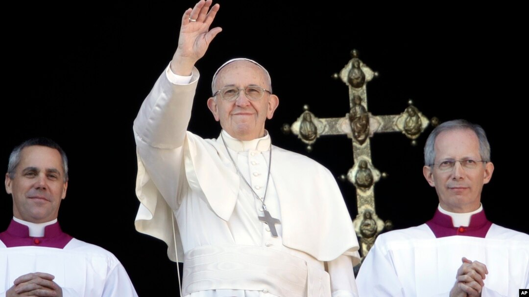 Paus Fransiskus melambai kepada kepada massa usai memberikan pesan Natal "Urbi et Orbi" di depan basilika Santo Petrus, Vatikan hari Senin (25/12). 