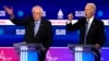 Democratic 2020 U.S. presidential candidates Senator Bernie Sanders and former Vice President Joe Biden talk at the tenth Democratic 2020 presidential debate at the Gaillard Center in Charleston, South Carolina, Feb. 25, 2020.