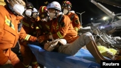 Rescue workers move a boy from the rubble of a collapsed hotel that has been used for medical observation following an outbreak of the novel coronavirus, in the southeast Chinese port city of Quanzhou, Fujian province, China, March 9, 2020.