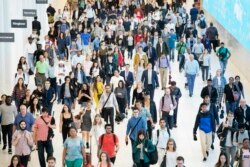 FILE - In this June 21, 2019, file photo commuters walk through a corridor in the World Trade Center Transportation Hub in New York. Millennial workers are more likely than older generations to…