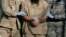FILE - A shackled detainee is being escorted away from an Administrative Review Board hearing, at Camp Delta detention center at the Guantanamo Bay U.S. Naval Base in Cuba, Dec. 6, 2006.