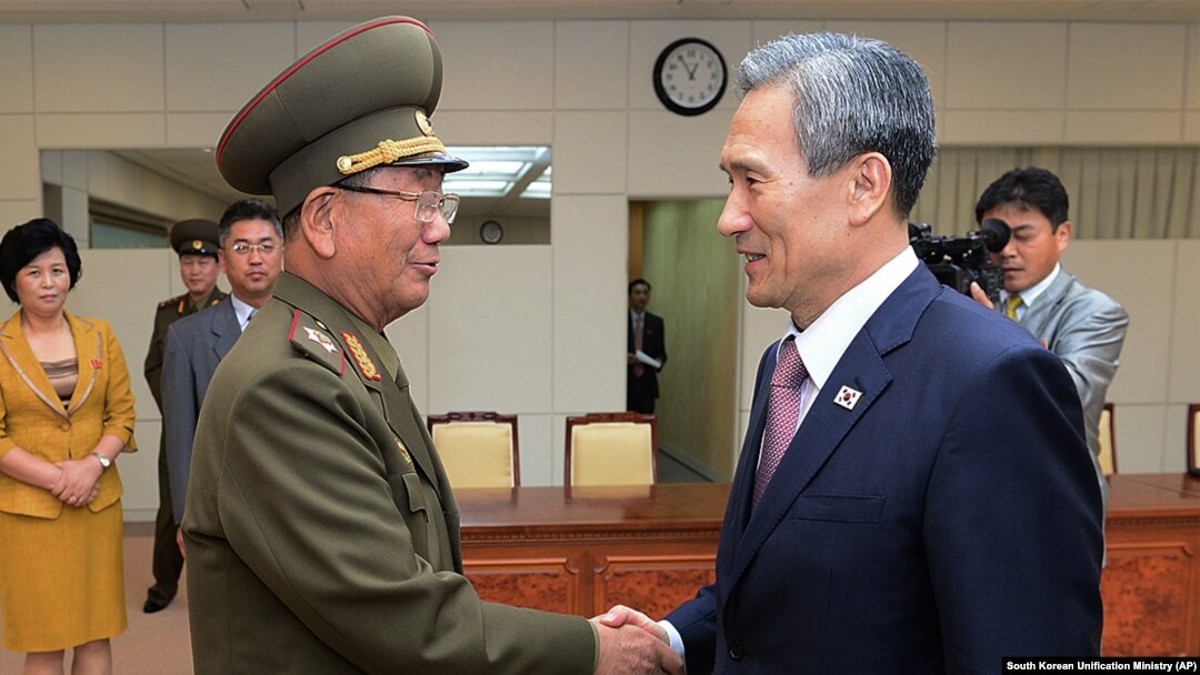 Kim Kwan-jin, la-taliyaha ammaanka madaxweynaha Korea-da Koonfureed (Midig), oo gacan qaadaya sarkaalka ugu sarreeya ciidamada Korea-da Waqooyi Hwang Pyong So (Bidix) Aug. 25, 2015. 