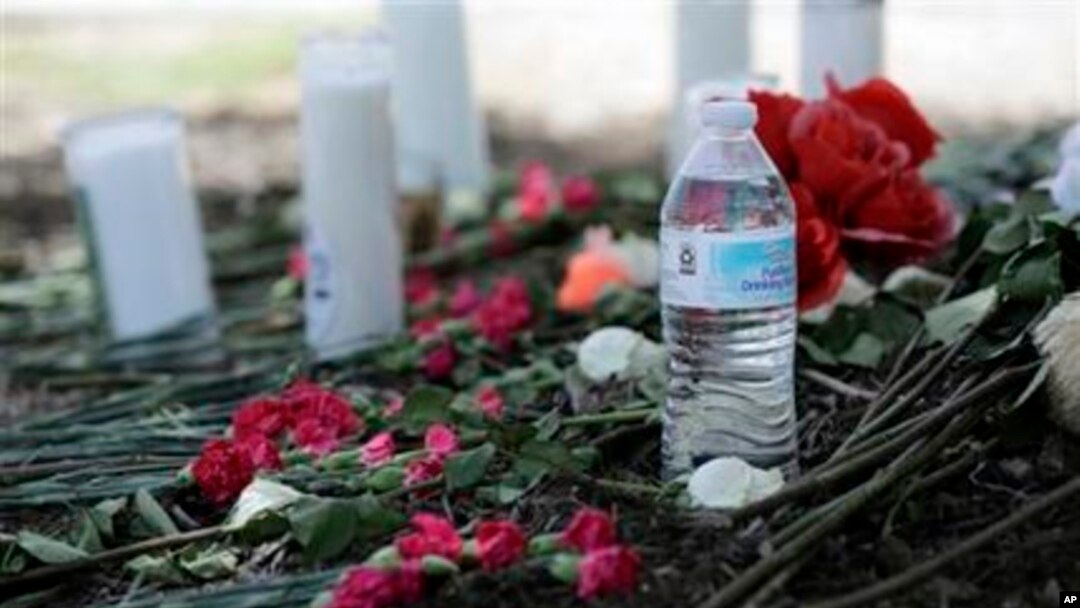 Una botella de agua, flores, velas y peluches fueron depositados en el lugar donde las autoridades descubrieron el sábado un tráiler lleno de inmigrantes en San Antonio, Texas, el lunes, 24 de julio de 2017. (AP Foto / Eric Gay)