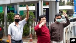 Activists Somyot Prueksakasemsuk, left, Parit Chiwarak and Arnon Nampa raise a three-finger salute, a symbol of resistance, as they arrive at criminal court in Bangkok, Thailand, Feb. 9, 2021. Activist Patiwat Saraiyaem is not pictured.