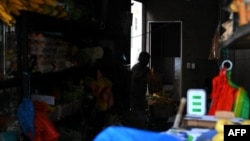 ARCHIVO - Una mujer compra frutas y vegetales en una tienda sin electricidad en Quito, el 25 de octubre de 2024. (ARCHIVO: AFP)