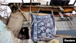 A Syrian refugee woman looks outside from inside her house in Ankara, Nov. 21, 2014. 