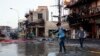 Anak-anak berjalan ke sekolah di lokasi serangan bom mobil, Baghdad, Irak, 18 Februari 2014.