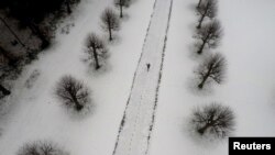 A person walks through the grounds of the Parish Church of Saint Mary and All Saints, in Whitmore, Staffordshire, Britain.