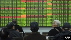 Para investor mengamati pergerakan harga-harga saham China bulan ini di kota Hangzhou, Zhejiang di tengah perebakan virus korona (foto: dok). 