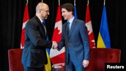 Денис Шмыгаль пожимает руку Джастину Трюдо в Торонто, Онтарио, Канада, 11 апреля 2023 года