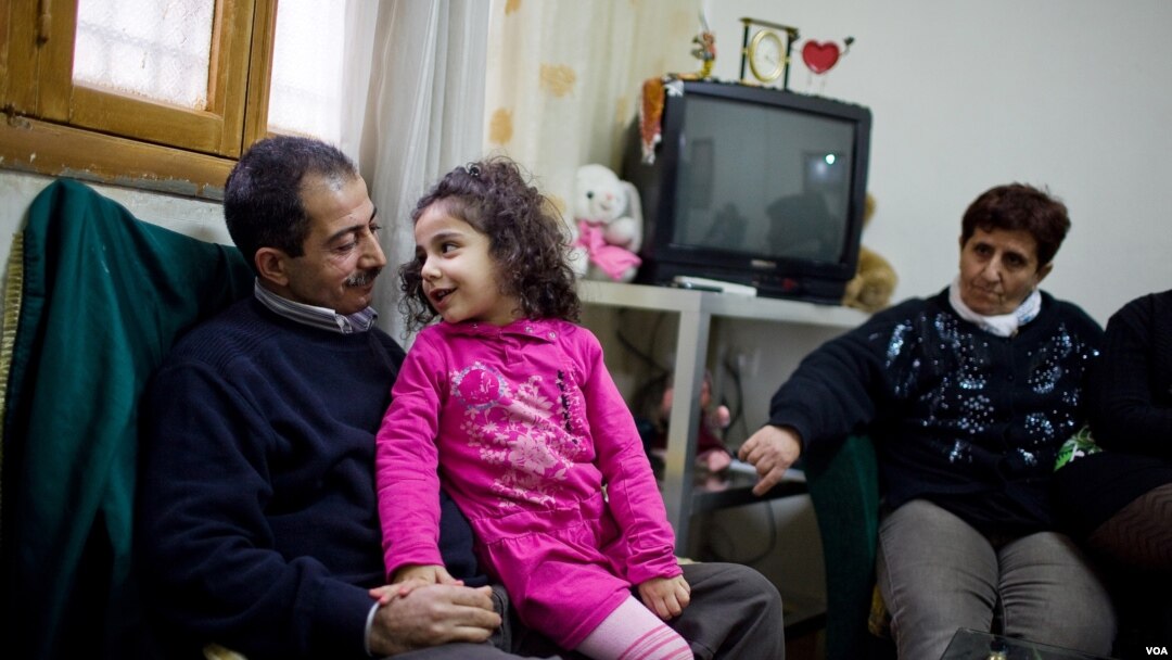 Daniel, an Armenian Orthodox from Syria, relaxes in Beirut with his 5-year-old daughter Antonella, while his mother-in-law looks on, December 2012. (VOA/V. Undritz)