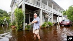 Charles Grainger limpia alrededor de su casa en el distrito histórico de French Quarter Creek mientras las aguas de la inundación de la tormenta tropical Debby retroceden, el 7 de agosto de 2024, en Huger, Carolina del Sur.