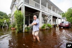 Charles Grainger membersihkan sekitar rumahnya pasca banjir akibat Badai Tropis Debby di Huger, South Carolina.