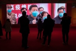 FILE - Residents attend an exhibition on the city's fight against the coronavirus in Wuhan, China, Jan. 23, 2021.