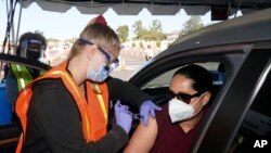 En esta foto del 2 de marzo de 2021, Vanessa Guerra, maestra de una escuela primaria, recibe una vacuna de Moderna en Los Angeles, California.