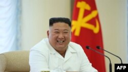 Kantor berita Korea Utara KNCA merilis foto pemimpin Korea Utara Kim Jong Un yang sedang tersenyum saat menghadiri pertemuan Biro Politik ke-13, 7 Juni 2020. (Foto: AFP)