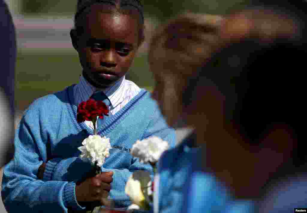 Schoolgirls from St. Theresa College Primary School hold flowers during a memorial service for migrant victims in Msida, outside Valletta, Malta. Italian Prime Minister Matteo Renzi said on Wednesday it was fundamental the EU take a collective stand to tackle migrant trafficking at its source in African countries, days after hundreds died in the latest Mediterranean disaster.