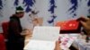 资料照 - 一名法国邮局工作人员展示一位名叫“吉姆”的台湾孩子邮寄给法国利布尔纳的一封慰问卡和口罩。