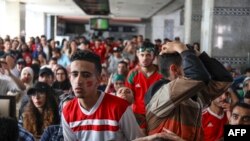 Les supporters du football marocain réagissent en regardant le match du Groupe B de la coupe du monde Russie 2018 contre l'Iran dans une gare de la capitale marocaine, Rabat, le 15 juin 2018. 