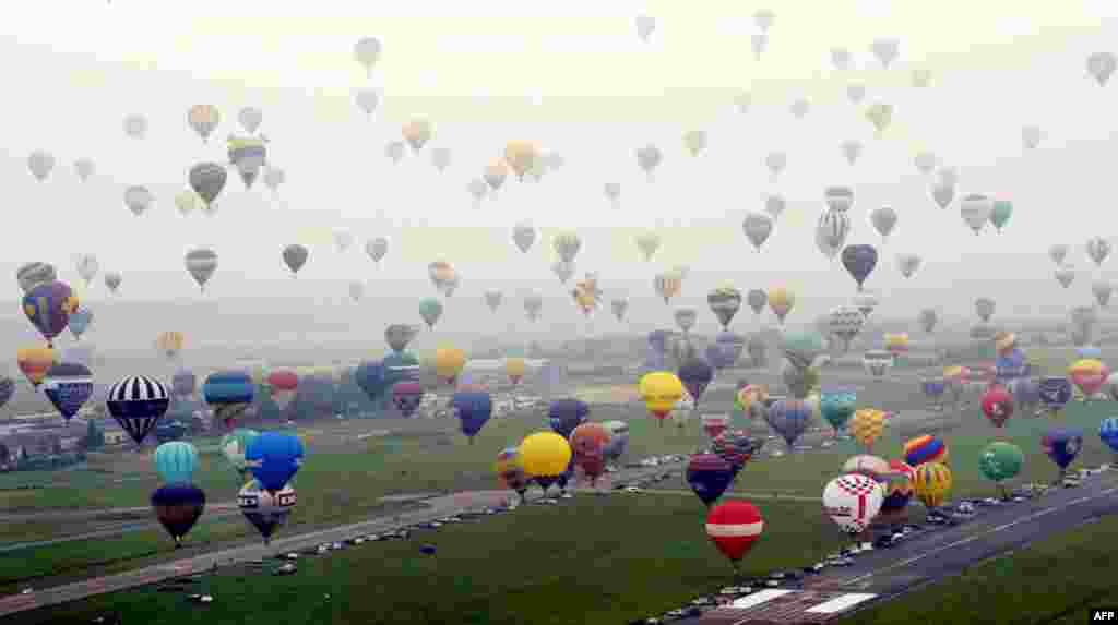 July 27: Hot-air balloons take off in Chambley-Bussieres, eastern France, during an attempt to set a world record for collective taking-off during the event "Lorraine Mondial air ballons." (AP Photo/ Alexandre Marchi)