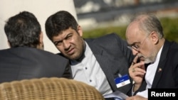 The head of Iranian Atomic Energy Organization Ali Akbar Salehi (R) looks over papers before meetings at the Beau Rivage Palace Hotel March 28, 2015 in Lausanne. 