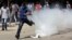 An Egyptian protester runs away from a tear gas canister fired by riot police, near street leading to U.S. embassy during clashes in Cairo, September 14, 2012.