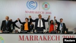 Le responsable du climat à l’ONU, Patricia Espinosa, deuxième à gauche, la ministre des Affaires étrangères du Maroc, Salaheddine Mezouar, au centre et l'ambassadeur de bonne volonté du Conseil de l'Europe, Bianca Jagger, deuxième à droite, célèbrent après la proclamation de Marrakech, lors de la cérémonie de clôture de la Conférence mondiale sur le climat de l'ONU, à Marrakech, Maroc, 17 novembre 2016.