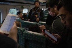 Travelers on a high speed train from Kaohsiung to Taipei read up on the post-election news near central Taiwan's Taichung city, Jan. 12, 2020