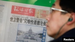 Seorang pria berdiri di depan salinan surat kabar Global Times. Koran tersebut menghapus pemberitaan di situs webnya mengenai campur tangan pemerintah di media. (Foto: Reuters)