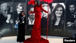 FILE - A woman poses at Saudi Arabia's first commercial movie theater in Riyadh, Saudi Arabia, April 18, 2018. 