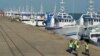 Patrulha de segurança passa por barcos da EMATUM na doca de Maputo.