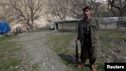 FILE - A Kurdistan Workers' Party (PKK) fighter stands guard at the Qandil mountains near the Iraq-Turkish border in Sulaimaniya, 330 km (205 miles) northeast of Baghdad, March 24, 2013.