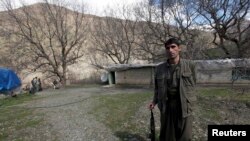 FILE - A Kurdistan Workers' Party fighter stands guard at the Qandil Mountains near the Iraq-Turkish border in Sulimaniyah, 330 km northeast of Baghdad, March 24, 2013.