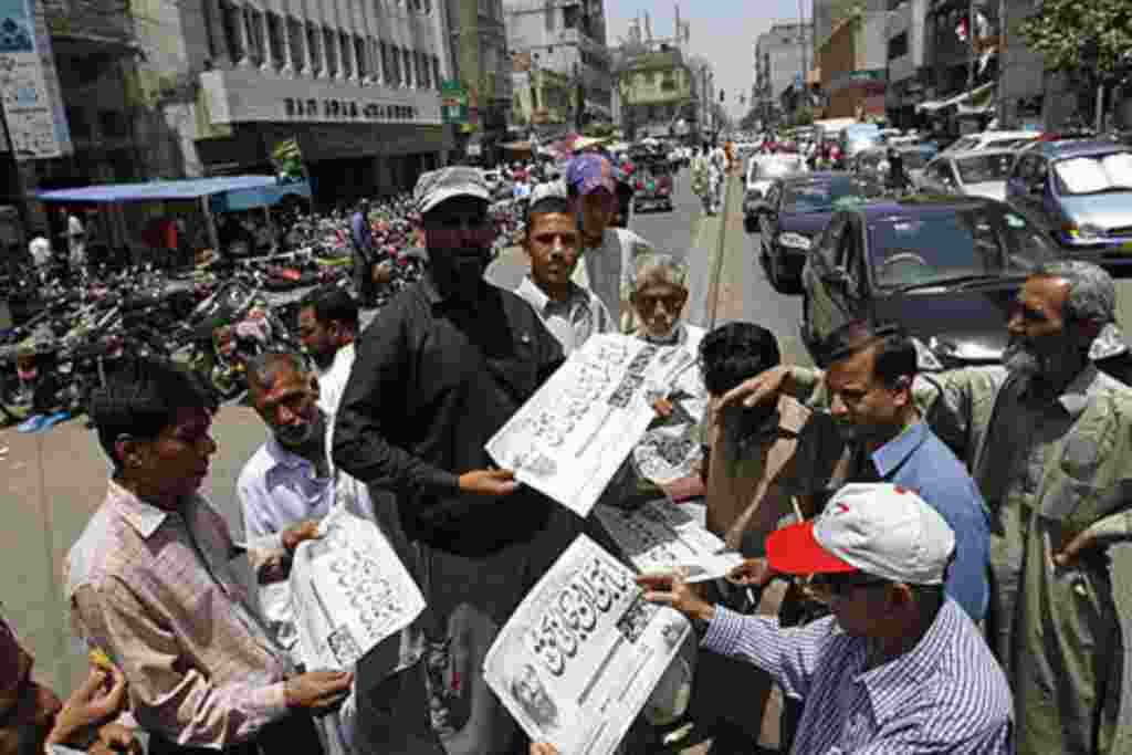 People in Karachi, Pakistan, buy newspapers reporting the killing of Osama bin Laden, May 2, 2011