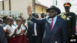 South Sudan President Salva Kiir waves as he greets schoolchildren at Juba International Airport in Juba on Sept. 13, 2018, after returning from the Ethiopian capital Addis Ababa where the latest peace agreement with opposition leader Riek Machar was finalized.