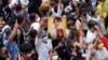 Myanmar nationals living in Thailand hold a picture of former Myanmar leader Aung San Suu Kyi during protest marking the two-year anniversary of the military takeover that ousted her government outside the Myanmar Embassy in Bangkok, Thailand, Feb. 1, 2023. 
