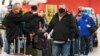 Travelers wait to check in for flights at LaGuardia Airport, Nov. 25, 2020, in Queens, New York. Millions of Americans are taking to the skies and hitting the road ahead of Thanksgiving at the risk of pouring gas on the COVID-19 fire.