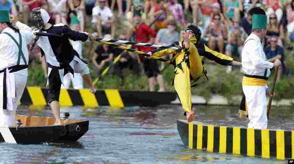 Two men fight with their lances at the traditional fishermen&#39;s joust tournament on river Danube in Ulm, southern Germany. The jousting contest with 16 jousting pairs in historic costumes represents historical figures and original characters of the city of Ulm.