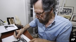 Syrian cartoonist Ali Ferzat works in Damascus, Syria, August 14, 2011 (file photo)